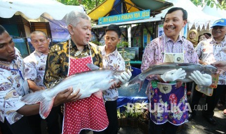 Sekda Jabar Iwa Karniwa (kanan) dan Kepala Dinas Kelautan dan Perikanan Jabar Jafar Ismail menggendong ikan patin pada Festival Lauk Juara dalam acara Gedung Sate Fest, di halaman belakang, Gedung Sate, Kota Bandung, Jumat (16/11). 