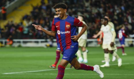 Lamine Yamal dari Barcelona merayakan gol pembuka timnya dalam pertandingan melawan Granada di La Liga Spanyol di Stadion Olimpic Lluis Companys di Barcelona, Spanyol, Senin (12/2/2024) dini hari WIB. 