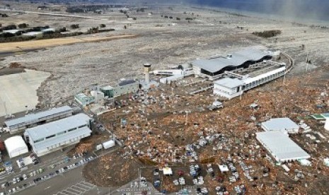 Lapangan parkir Bandara Sendai penuh dengan lumpur dan sampah serta puing-puing bangunan yang terbawa tsunami pada Jumat. 