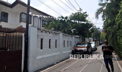 Warga melintas di samping mobil yang parkir pada bahu jalan. (Ilustrasi)