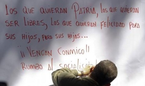 Late Venezuelan President Hugo Chavez writes a message after signing his support for a proposal to change the constitution, in Caracas in this December 11, 2008 file photo.