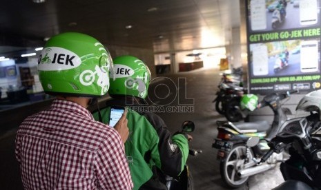 Layanan ojek motor berbasis aplikasi, Gojek, membawa penumpangnya.