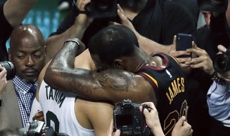  LeBron James (kanan) merangkul Jayson Tatum setelah Cavaliers berhasil mengalahkan Boston Celtics 87-79 di gim penentuan final wilayah timur, Senin (28/5) WIB pagi, di Boston. Hasil ini membuat Cavaliers melaju ke babak final NBA. 