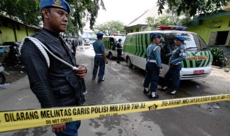   Petugas berjaga di depan gerbang dermaga gudang Amunisi Satuan Komando Pasukan Katak yang hancur akibat ledakan di Kawasan Armada Barat di Pondok Dayung, Jakarta Utara, Rabu (5/3).    (Republika/Yasin Habibi)