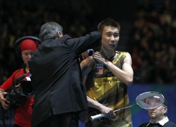 Lee Chong Wei (kanan), pebulutangkis Malaysia, mendapatkan perawatan sebelum akhirnya mundur dari partai final tunggal putra lawan Lin Dan asal Cina di turnamen All England di Birmingham, Inggris, Ahad (11/3). 