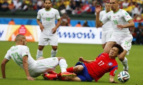 Lee Chung-yong (tengah) dari Korea Selatan dalam aksi melawan pemain Aljazair Islam Slimani (kiri) dan Nabil Bentaleb (kanan) selama Piala Dunia FIFA 2014 grup H pertandingan babak penyisihan antara Korea Selatan dan Aljazair di Estadio Beira-Rio di Porto 