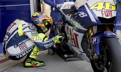 Legenda balap MotoGP Valentino Rossi sedang berbicara dengan motornya dalam sebuah race MotoGP beberapa waktu lalu. 