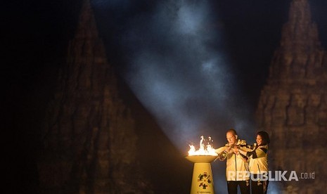 Legenda bulu tangkis Indonesia Susi Susanti (kanan) dan mantan atlet tenis Yustedjo Tarik (kiri) mengambil api obor Asian Games 2018 yang telah disatukan saat Asian Games 2018 Torch Relay Concert di Kompleks Candi Prambanan, Sleman, DI Yogyakarta, Rabu (18/7). Penyatuan api obor dari India dan Mrapen tersebut menandai dimulainya perjalanan api obor Asian Games 2018 yang akan dibawa berlari mengelilingi 18 provinsi. 