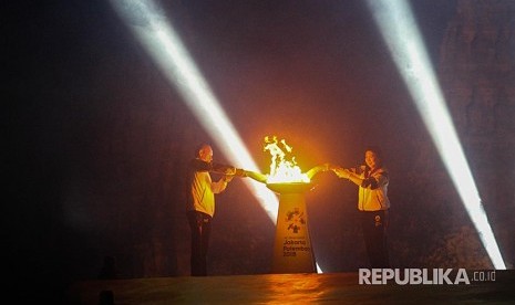 Legenda bulu tangkis Indonesia Susi Susanti (kanan) dan mantan atlet tenis Yustedjo Tarik (kiri) mengambil api obor Asian Games 2018 yang telah disatukan saat Asian Games 2018 Torch Relay Concert di Kompleks Candi Prambanan, Sleman, DI Yogyakarta, Rabu (18/7). Penyatuan api obor dari India dan Mrapen tersebut menandai dimulainya perjalanan api obor Asian Games 2018 yang akan dibawa berlari mengelilingi 18 provinsi. 