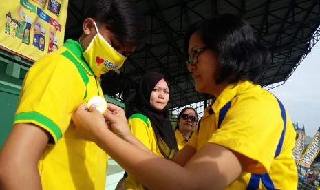  Lenny R Sianturi selaku Head of Cough and Cold PT Saka Farma menyematkan pin kepada agen gerakan bebas batuk di Cimahi, belum lama ini.