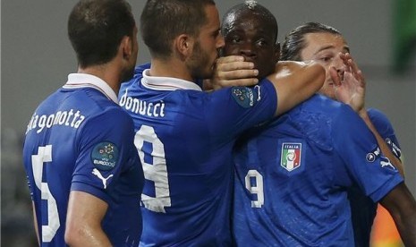 Leonardo Bonucci (dua kiri), pemain timnas Italia, menutup mulut striker Mario Balotelli yang melakukan selebrasi usai menjebol jala Republik Irlandia di laga Grup C Piala Eropa 2012. 