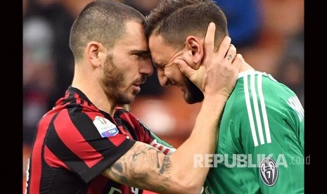 Leonardo Bonucci (kiri) menenangkan Gianluigi Donnarumma pada pertandingan Piala Itala antara AC Milan dan Hellas Verona di San Siro Stadium, Milan, Kamis (14/12) dini hari.