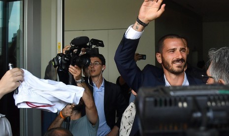 Leonardo Bonucci melambaikan tangan kepada fan saat keluar dari kantor AC Milan, di Milan, Italia, Jumat (14/7).