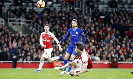 Leurent Koscielny menjatuhkan badan saat mencetak gol kedua Arsenal ke gawang Chelsea.