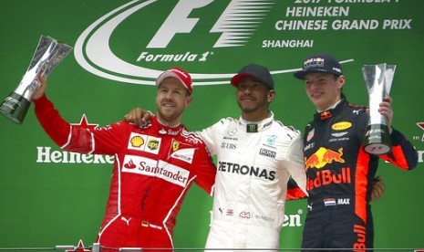 Lewis Hamilton (tengah) di podium juara GP Cina, Ahad (9/4).