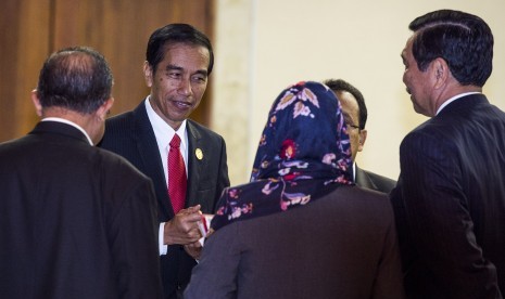 Liaison Officer mengibarkan bendera negara-negara OKI sebagai penanda posisi saat sesi foto bersama Kepala Negara dan Kepala Delegasi KTT Luar Biasa ke-5 OKI mengenai Palestina dan Al-Quds Al-Sharif di Jakarta Convention Center, Jakarta, Senin (7/3).