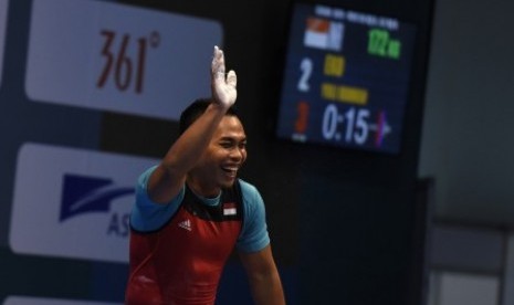 LIfter Indonesia Eko Yuli Irawan melambai usai melakukan angkatan clean and jerk pada nomor putra 62 kg 18th Asian Games Invitation Tournament di JiExpo, Jakarta, Ahad (11/2). 