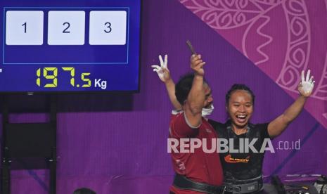 Lifter Jawa Barat Susi Susanti (kanan) meluapkan kegembiraan bersama pelatihnya usai berhasil memecahkan rekor Asia pada angkatan dead lift sekaligus memastikan medali emas dalam nomor angkat berat 52 kg putri PON Papua di Jayapura, Papua, Senin (11/10/2021). Susi Susanti berhasil memecahkan rekor Asia pada angkatan dead lift dengan angkatan 197,5 kg sekaligus memastikan medali emas untuk Jawa Barat dengan total angkatan 542,5 kg.