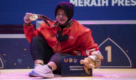 Lifter putri Jawa Tengah Diah Ayu P menunjukkan medalinya usai upacara pengalungan medali angkat besi kelas 76 kg PON Papua di Auditorium Universitas Cenderawasih, Kota Jayapura, Papua, Jumat (8/10/2021). Lifter putri Jawa Tengah Diah Ayu P berhasil meraih medali emas dengan total angkatan 215 Kg sementara medali perak diraih lifter Lampung Fena Yuliana dengan total angkatan 197 Kg.