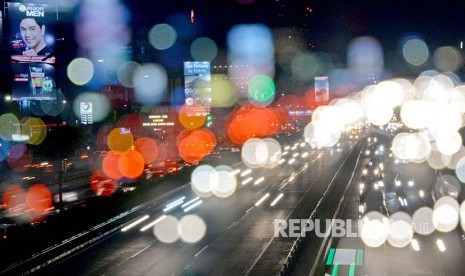 Lintasan sinar lampu mobil berpadu dengan lansekap kota malam hari di salah satu sudut kota Jakarta.