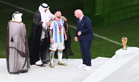 Lionel Messi dari Argentina menerima jubah tradisional Arab dari Tamim bin Hamad Al Thani (2-L), Emir Qatar, saat Presiden FIFA Gianni Infantino (kanan) melihat setelah Final Piala Dunia FIFA 2022 antara Argentina dan Prancis di stadion Lusail, Lusail , Qatar,   Ahad (18/12/2022). Mengenal Bisht, Jubah Kebanggaan Raja-Raja Arab yang Dipakai Messi Saat Angkat Trofi