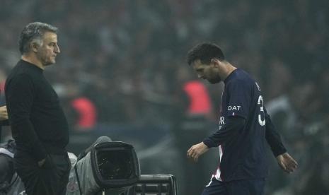  Lionel Messi dari PSG (kanan) meninggalkan lapangan saat pergantian pemain ketika pelatih kepala PSG Christophe Galtier menyaksikan pertandingan sepak bola Liga Satu Prancis antara Paris Saint-Germain dan Marseille di Parc des Princes di Paris, Ahad (16/10/2022)..