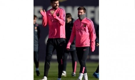 Lionel Messi (kanan) bersama Gerard Pique dalam sesi latihan Barcelona akhir tahun lalu. 