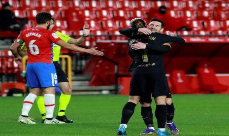 Lionel Messi (kanan) dan Antoine Griezmann berpelukan marayakan gol Barcelona ke gawang Granada pada laga lanjutan La Liga, Ahad (10/1) dini hari WIB. Barcelona menang 4-0.