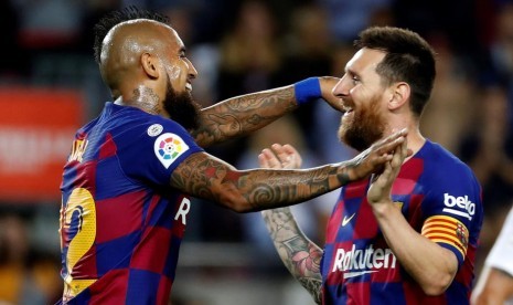 Lionel Messi (kanan) dan Arturo Vidal merayakan gol ke gawang Sevilla.