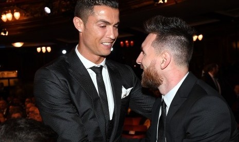 Lionel Messi (kanan) dan Cristiano Ronaldo bersalaman dalam acara penghargaan FIFA di London, Senin (23/10).