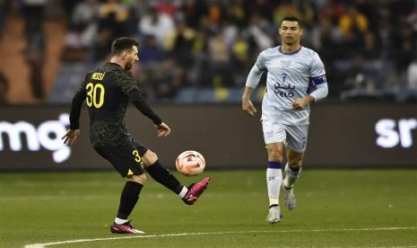 Lionel Messi (kiri) beraksi disaksikan Cristiano Ronaldo dalam laga ekshibisi antara Paris Siant-Germain (PSG) melawan Riyadh All Star di Riyadh, Jumat (20/1/2023) dini hari WIB. PSG mengalahkan Riyadh All Star 5-3.