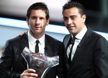 Lionel Messi (kiri) bersama Xavi Hernandez saat menerima penghargaan 'Pemain Terbaik di Eropa' 2011.