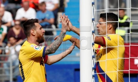 Lionel Messi (kiri) dan Luis Suarez merayakan gol.