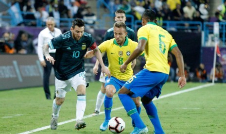 Lionel Messi (kiri) dijaga dua pemain Brasil.