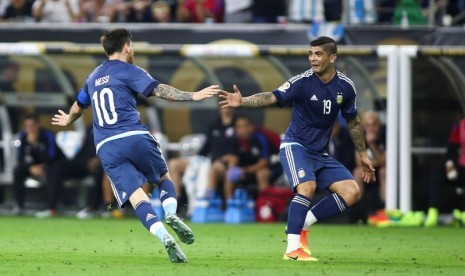 Lionel Messi (kiri) merayakan golnya bersama Ever Banega.