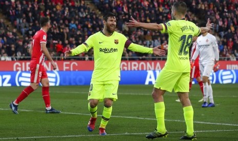 Lionel Messi (tengah) setelah mencetak gol ke gawang Girona.