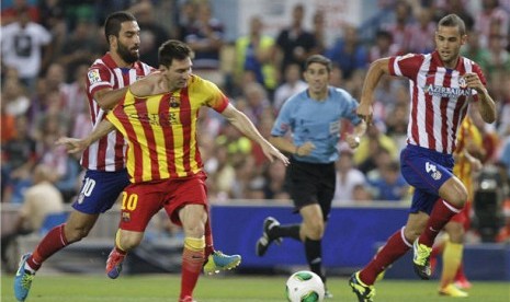 Lionel Messi (tengah), striker andalan Barcelona, menggiring bola saat menghadapi Atletico Madrid di leg pertama Piala Super Spanyol di Vicente Calderon, Madrid, Rabu (21/8). 