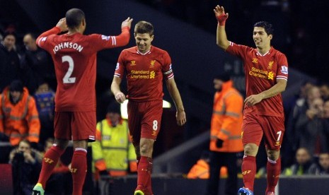 Liverpool's Luis Suarez, right, celebrates after scoring the second goal of the game with teammates Steven Gerrard, center, and Glen Johnson during their English Premier League soccer match against Norwich City at Anfield in Liverpool, England, Wednesday D