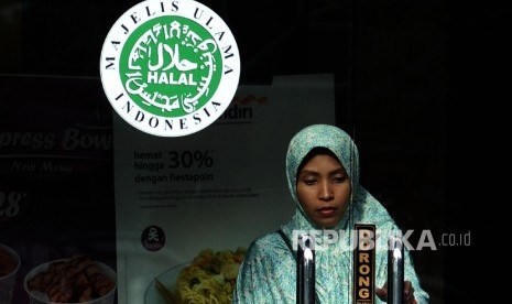 Logo halal Majelis Ulama Indonesia (MUI) terpampang dipintu masuk salah satu restoran cepat saji di Jakarta, Ahad (16/10).