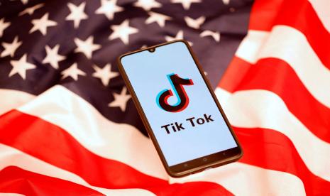 Logo TikTok ditampilkan di smartphone sambil berdiri di atas bendera AS dalam gambar ilustrasi yang diambil, 8 November 2019. 