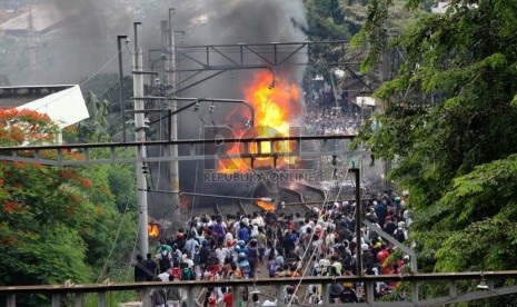 Smoke rises after A commuterline crashed with a tanker truck due to gate malfunction at Bintaro railway crossing on Monday, Dec. 9, 2013.