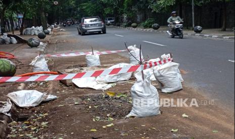 Lokasi lubang galian kabel di Jalan Tamansari, Kota Bandung dipasangi garis tanda peringatan, Jumat (13/12/2024). Seorang pengendara motor mengalami kecelakaan tunggal usai menabrak beton penutup lubang galian kabel, Kamis (12/12/2024) malam. 