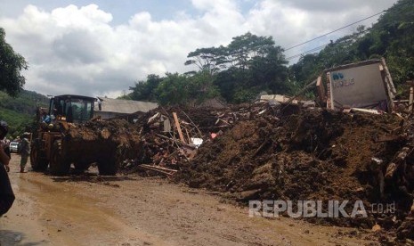  Alat berat berusaha membuka jalan yang tertutup longsor di daerah Ciherang, Kabupaten Sumedang, Rabu (21/9).