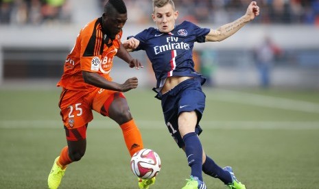 Lorient's Lamine Gassama (L) fights for the ball with Paris St Germain's Lucas Digne during their French Ligue 1 soccer match at the Moustoir stadium in Lorient November 1, 2014