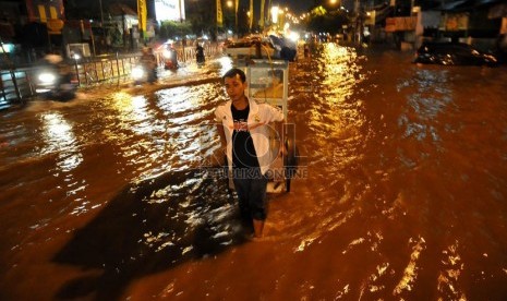 Luapan air Kali Ciliwung merendam Jalan KH Abdullah Syafe'i, Kampung Melayu Besar, Jakarta, Ahad (12/1) malam.  (Republika/Prayogi)