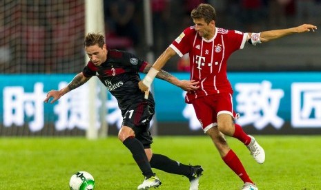 Lucas Biglia (kiri) membela AC Milan melawan Bayern Muenchen pada laga International Champions Cup. Biglia termasuk satu dari 11 pemain teranyar Milan musim ini. Milan membeli sembilan pemain dan meminjam dua pemain pada bursa transfer musim panas ini. 