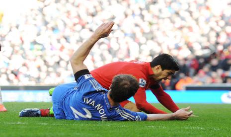 Luis Suarez (kanan) sesaat setelah menggigit bek Chelsea Branislav Ivanovic pada kompetisi Liga Primer Inggris musim 2012/2013.