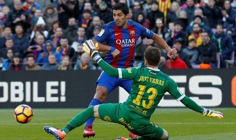 Luis Suarez saat menaklukkan kiper Las Palmas Javi Varas.