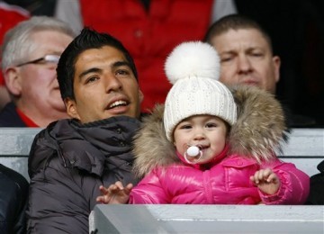 Luis Suarez, striker Liverpool, menggendong anak perempuannya, Delfina, melihat laga Piala FA antara Liverpool lawan Manchester United di Stadion Anfield, Liverpool, Sabtu (28/1). 