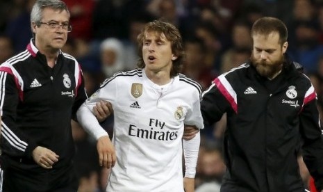 Luka Modric (tengah) saat dipapah keluar lapangan akibat cedera.